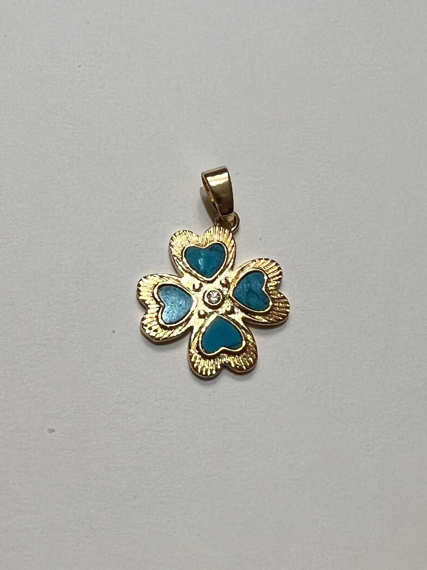 Gold pendant with blue stones on a gray background