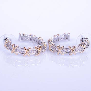 Pair of gold and silver hoop earrings on a light gray background