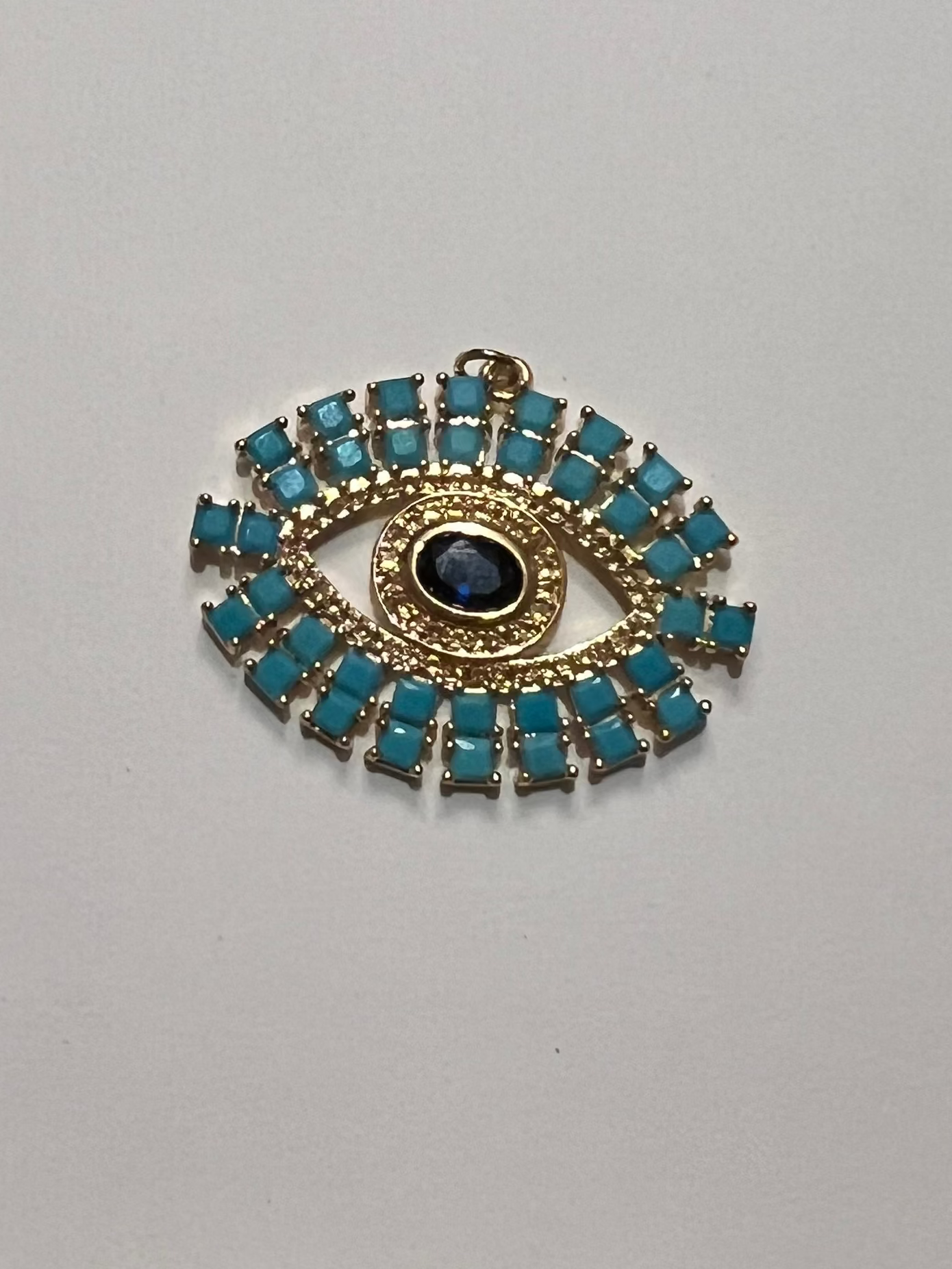 Decorative brooch with blue gemstones and gold accents on a white background