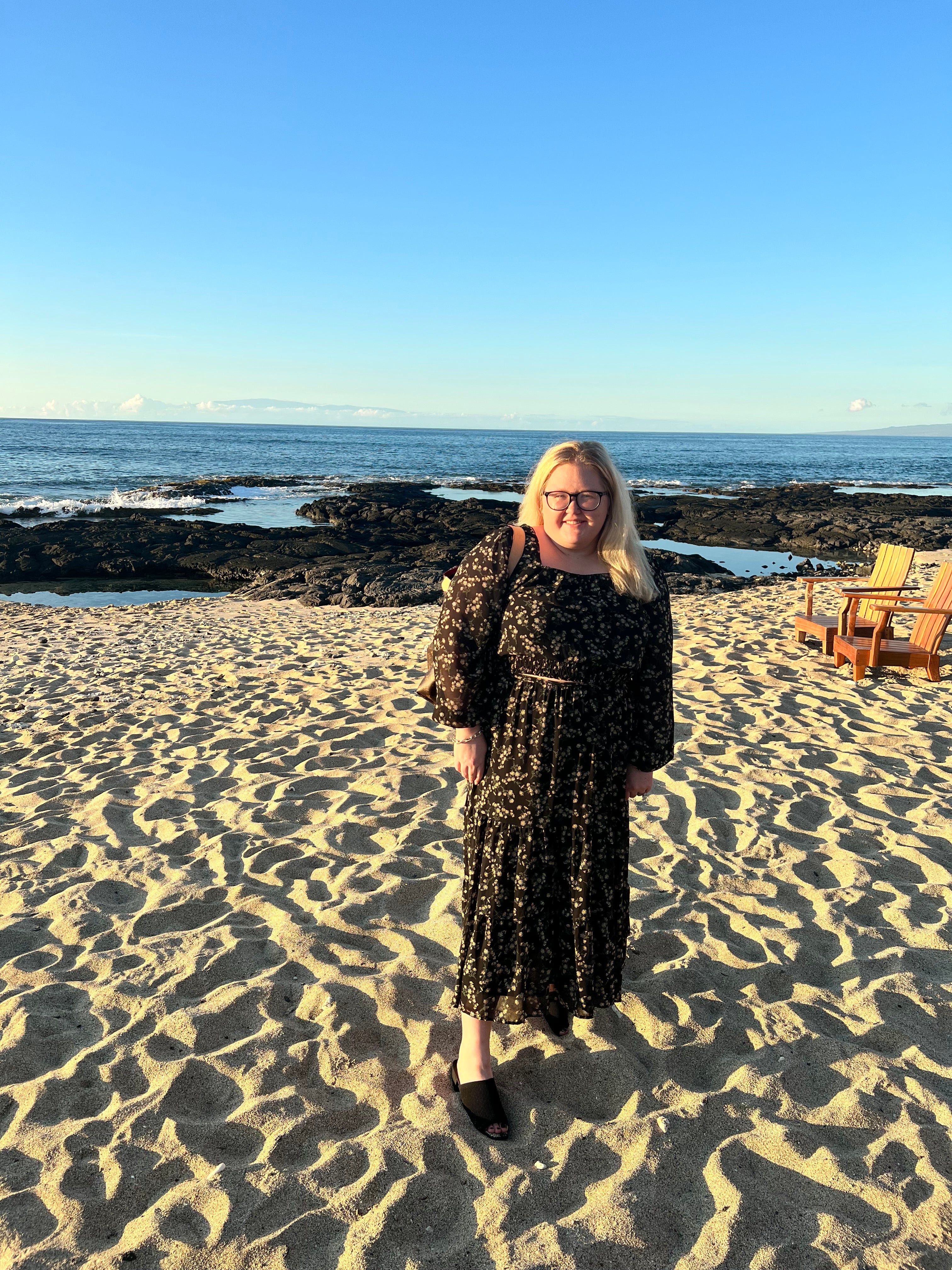 Person standing on a beach with clear blue sky
