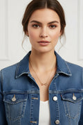 Gold necklace with a horse bit pendant on a white background